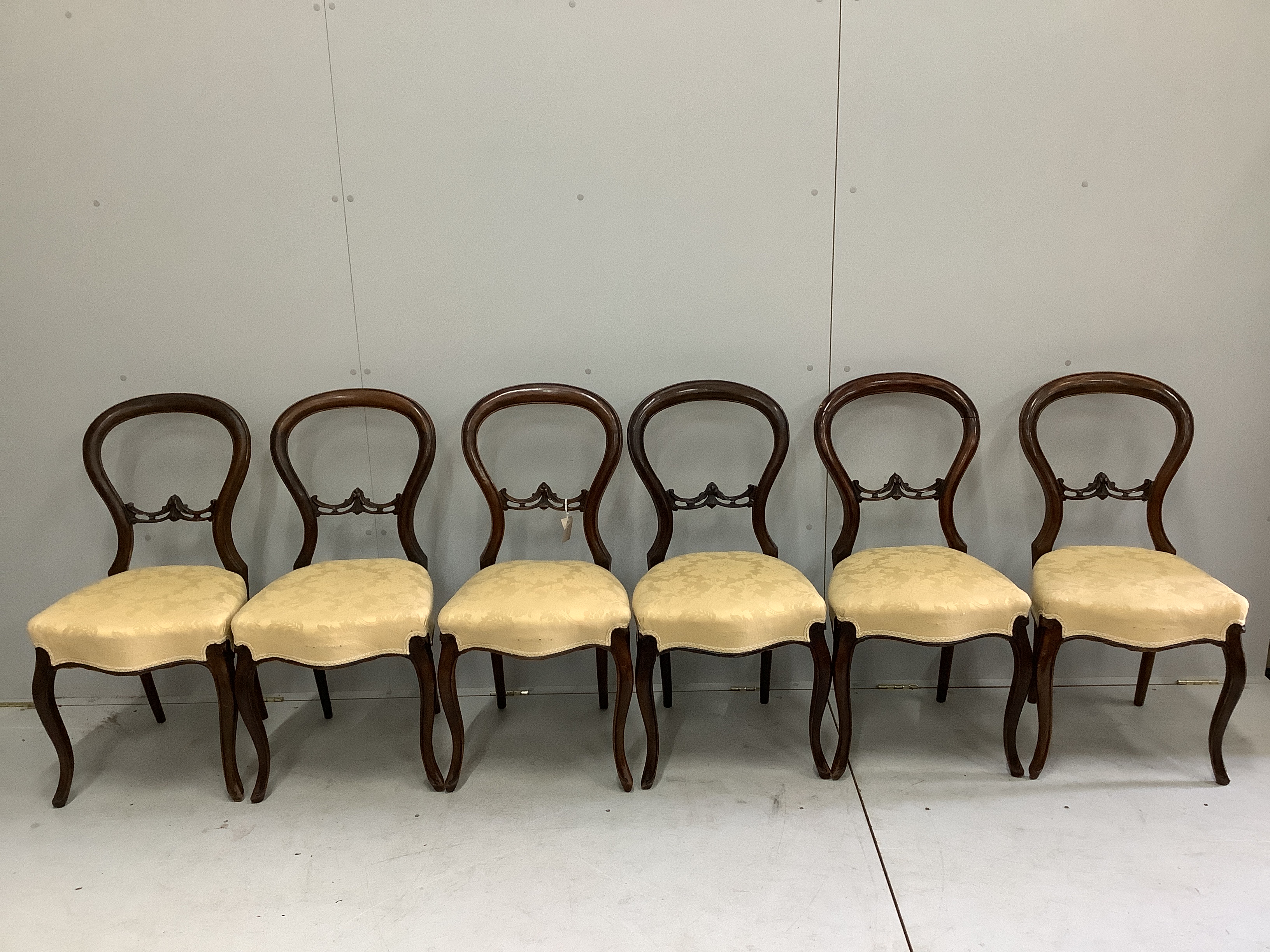 A set of six Victorian walnut balloon back dining chairs